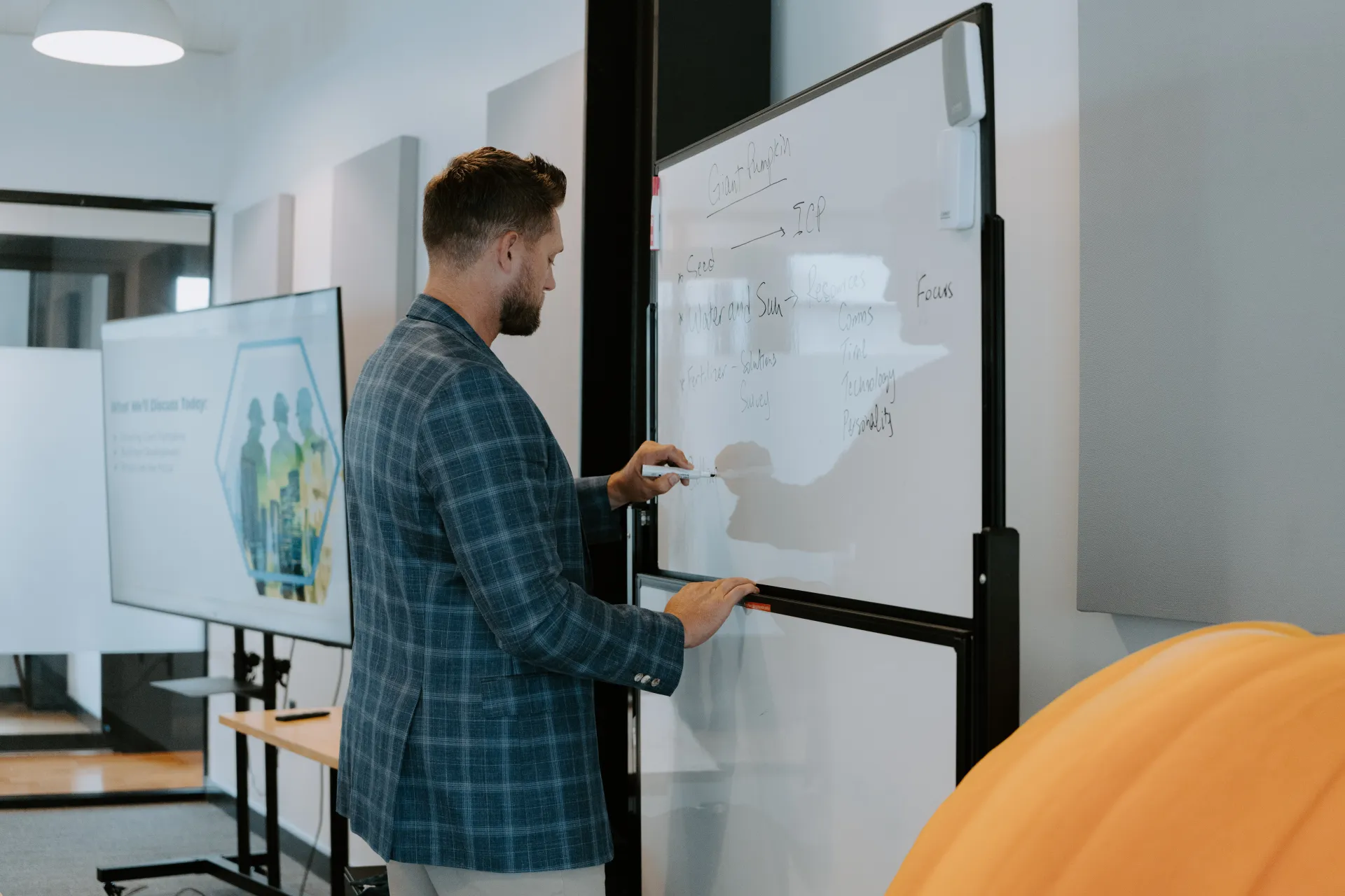 An STG coach teaching the Baseline Selling framework at a whiteboard